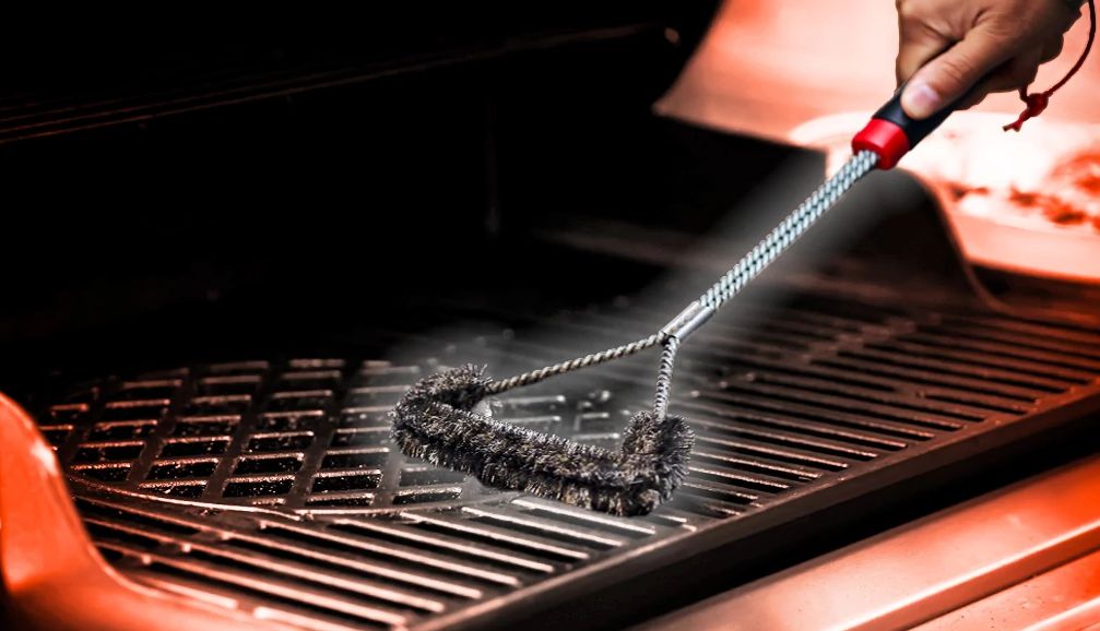 Weber grill spark electrode cleaning with wire brush close-up