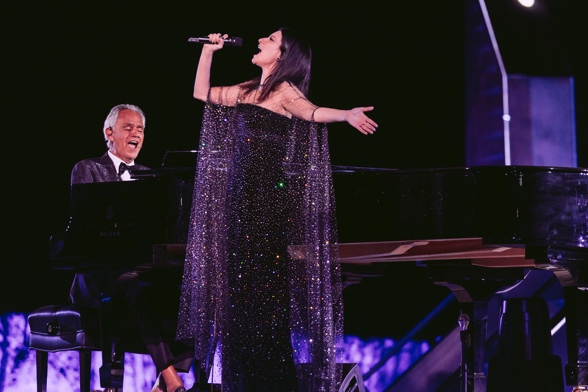 andrea bocelli performs on stage in a duet