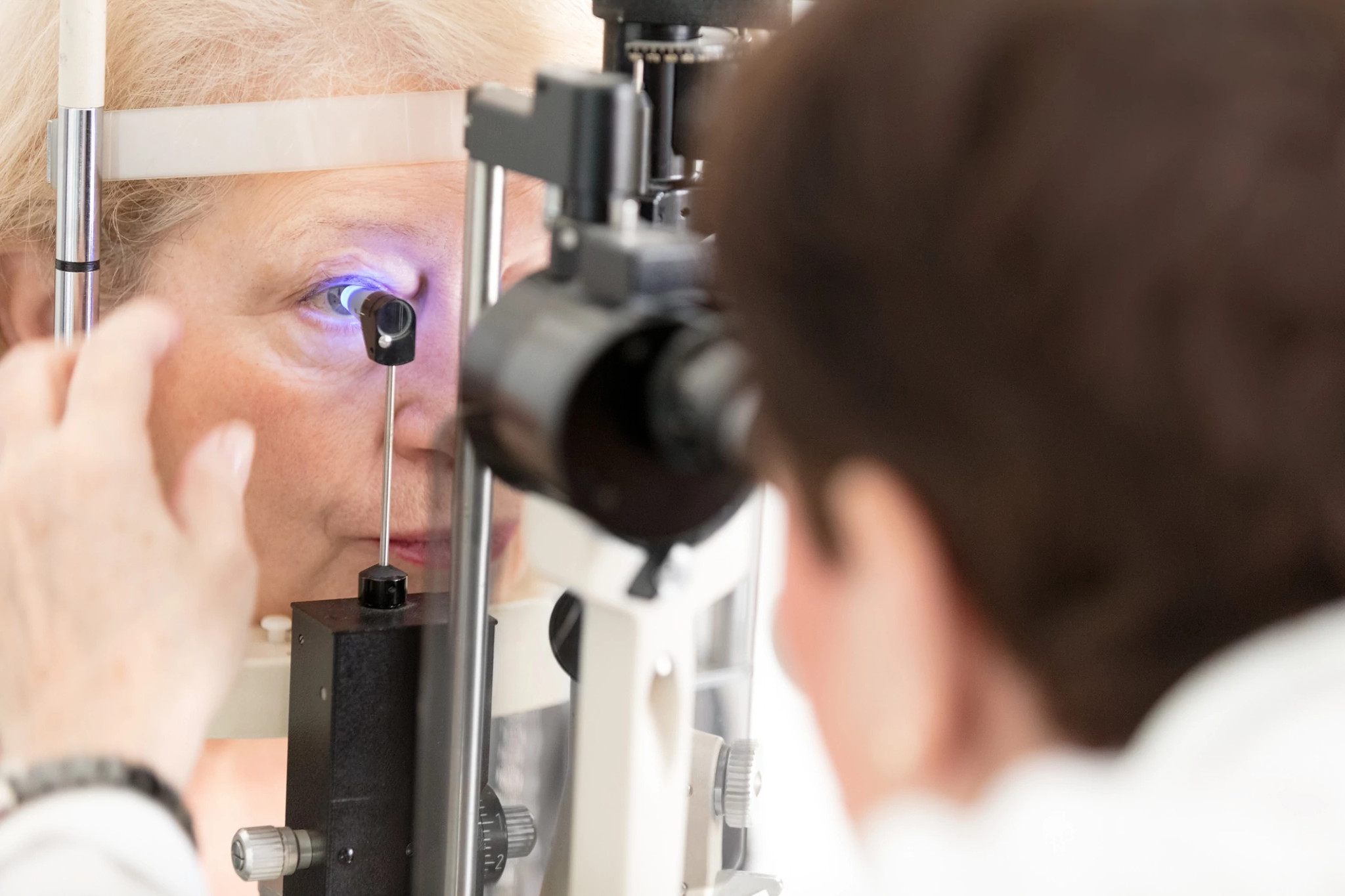 a doctor performing a tonometry test on a woman