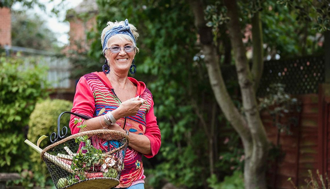 Working in your yard or garden helps the body and brain A woman carrying rhubarb from her garden in a basket