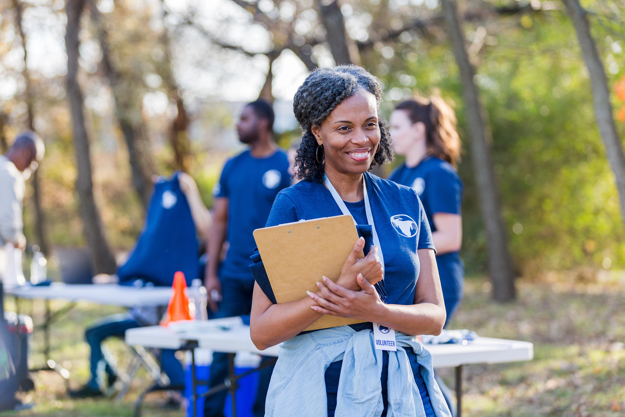 a woman smiling while holding a clipboard