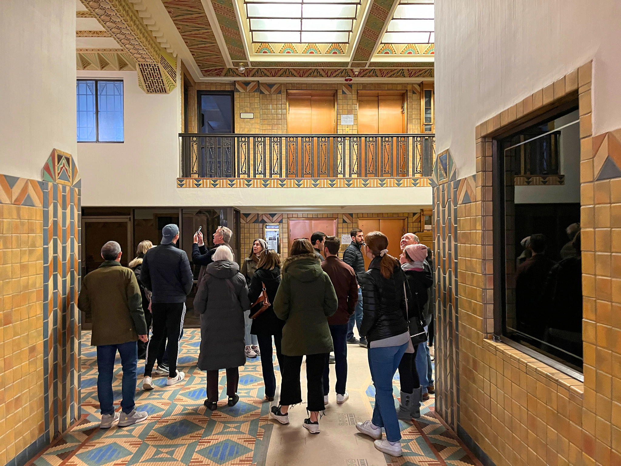 people standing together in a room with art deco architecture