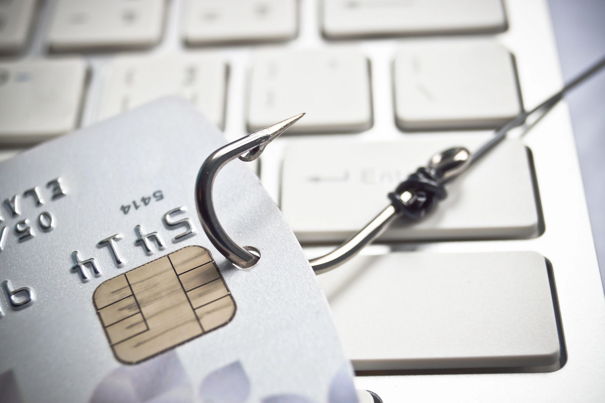 a credit card with a fish hook through it