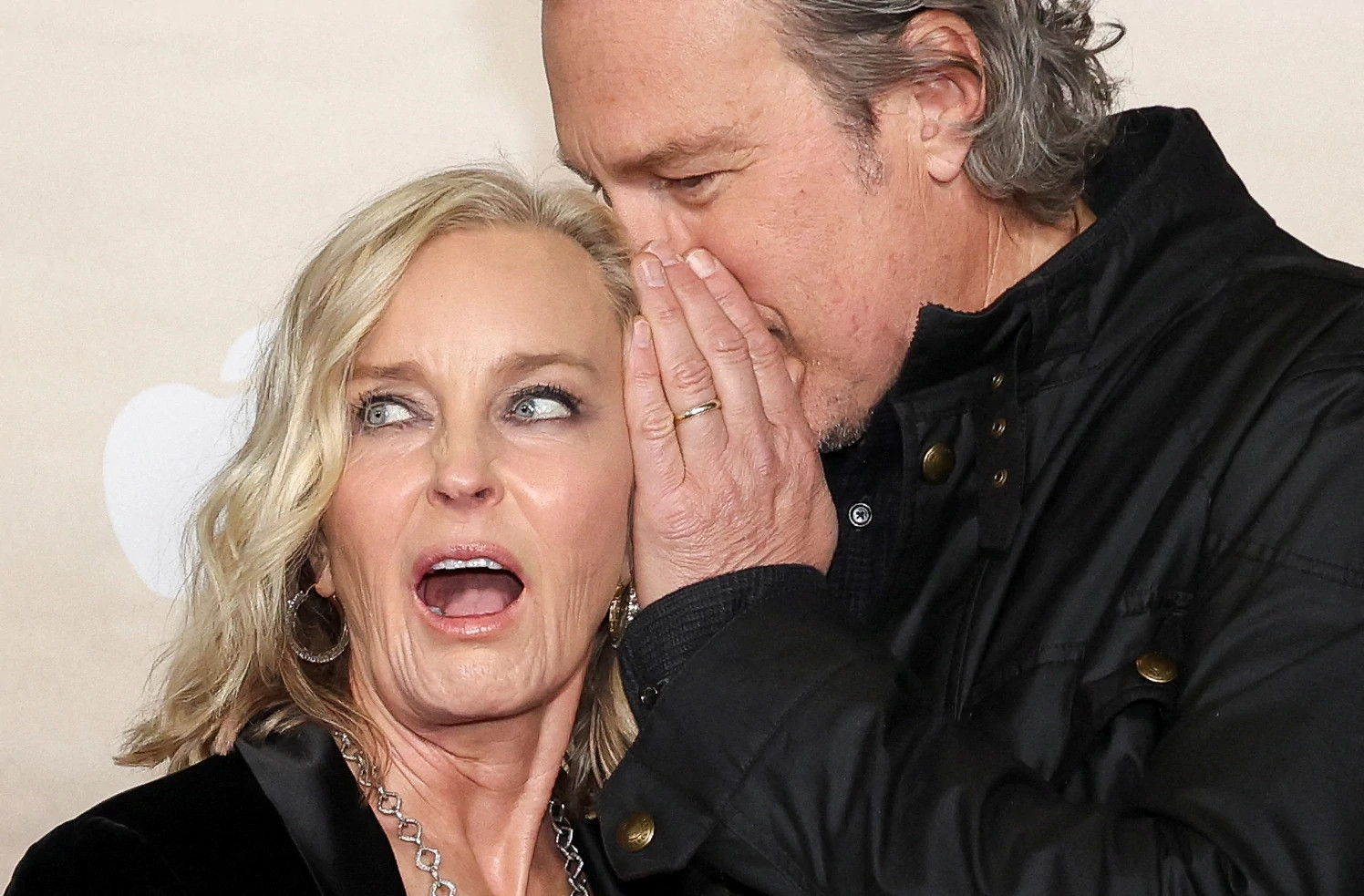 John Corbett whispering into Bo Derek's ear during a red carpet appearance at the Masters of the Air premiere