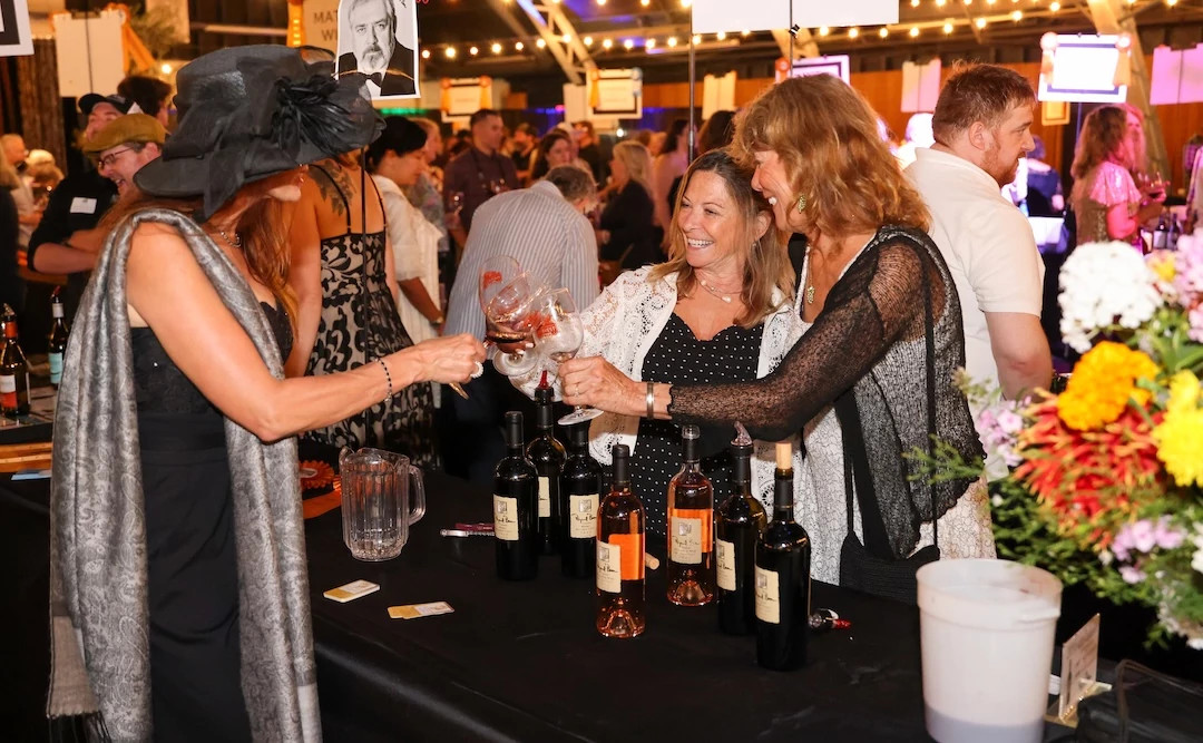 Colorful Fall Fests a group of women clinking wine glasses and smiling at an event