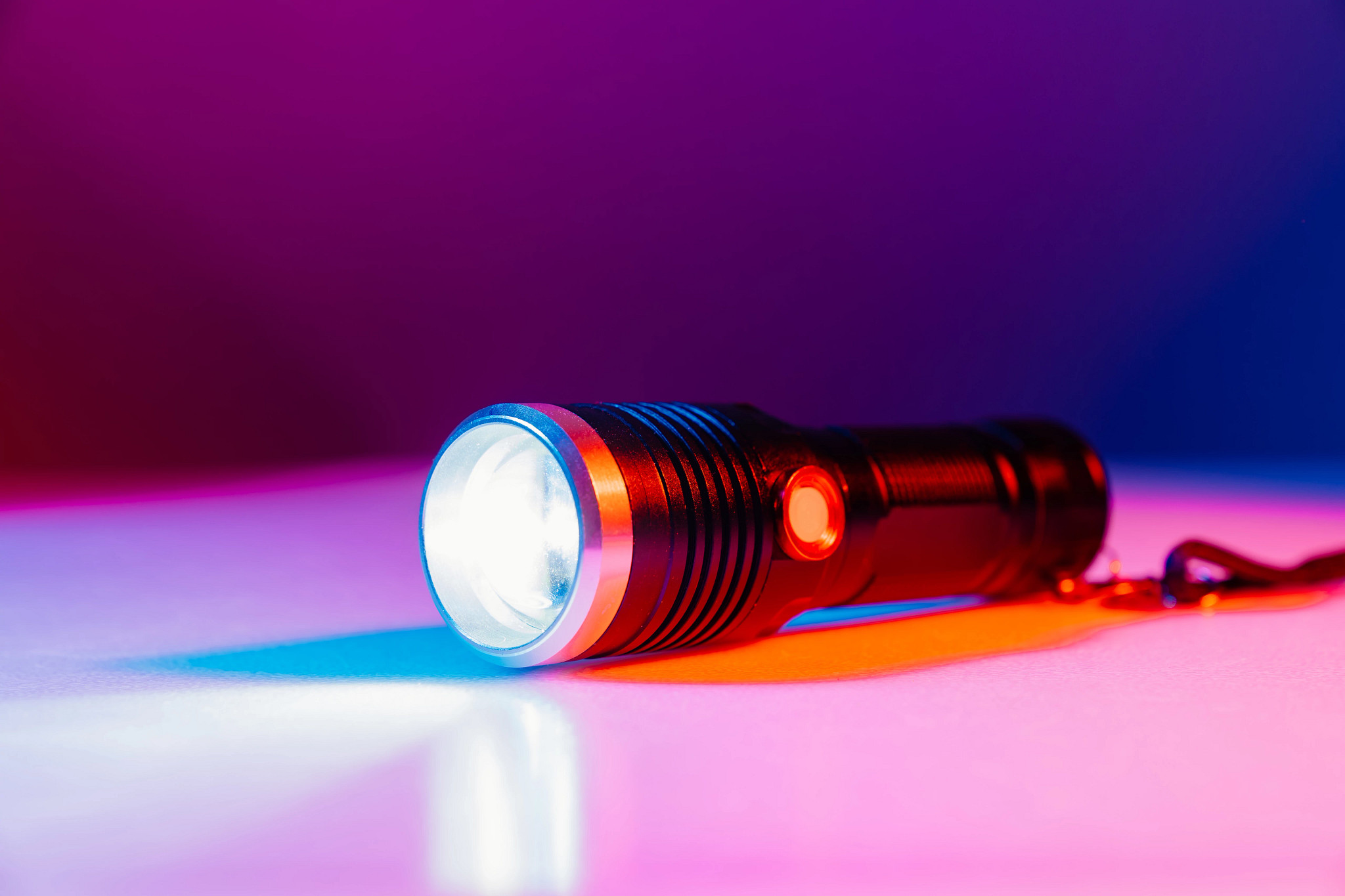 a photo shows a flashlight atop a fuchsia surface