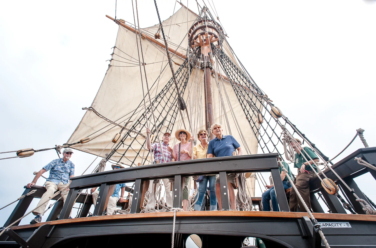 people looking out of frame and smiling on a sailboat at the Maritime Museum of San Diego