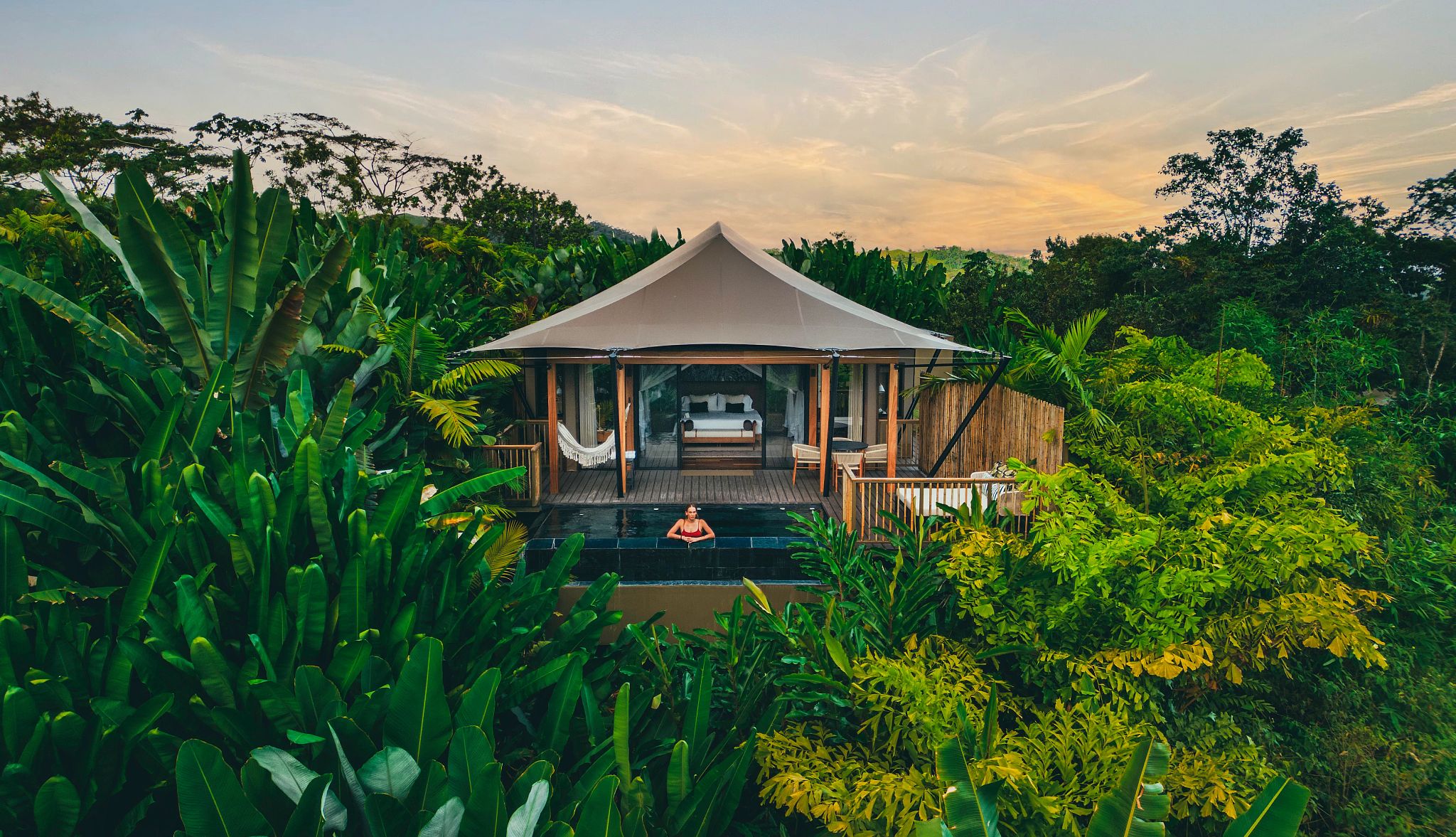 consider an eco-tourism trip to Costa Rica man standing in a pool at the Nayara Tented Camp