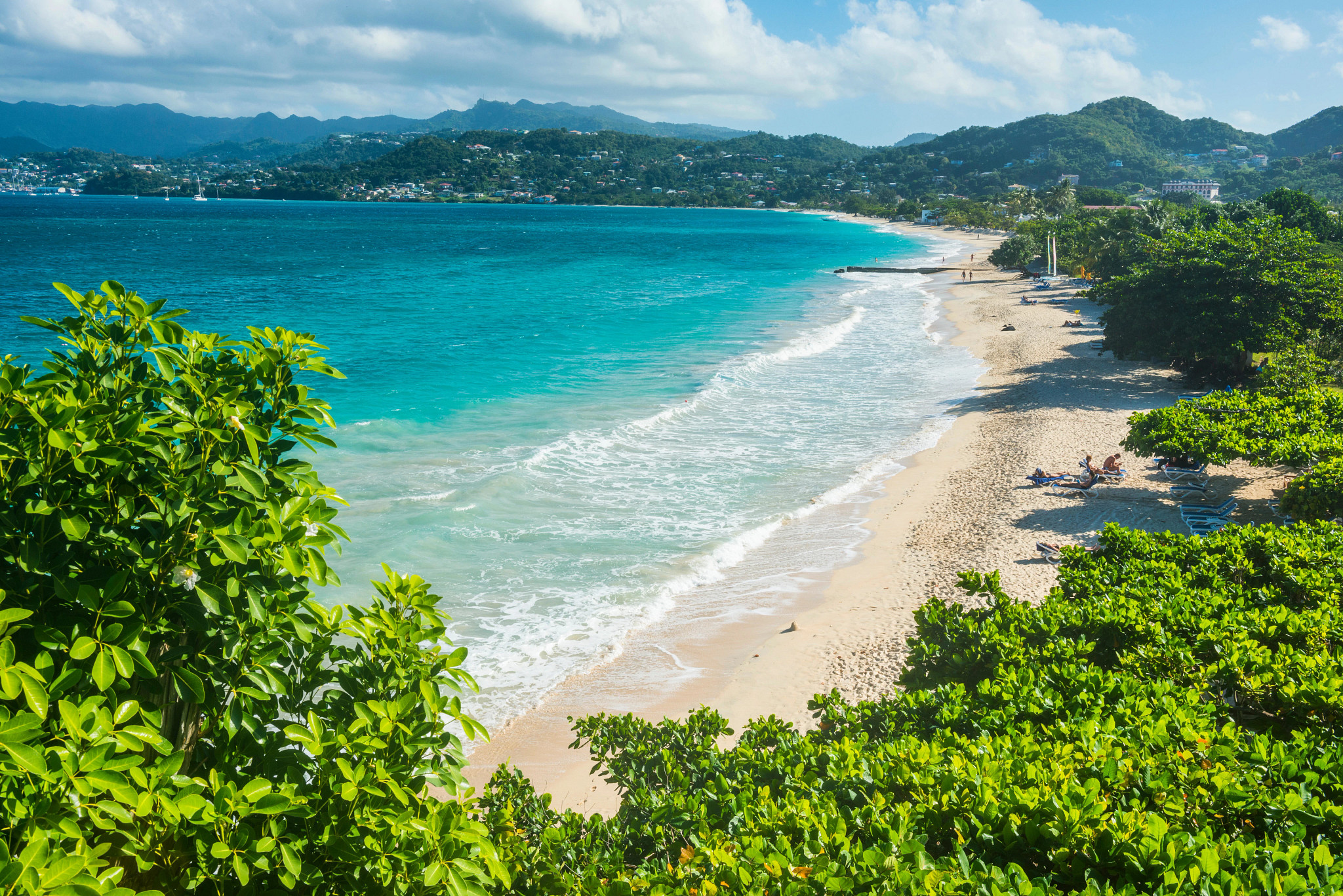a long stretch of beach with a few beachgoers scattered along the sand