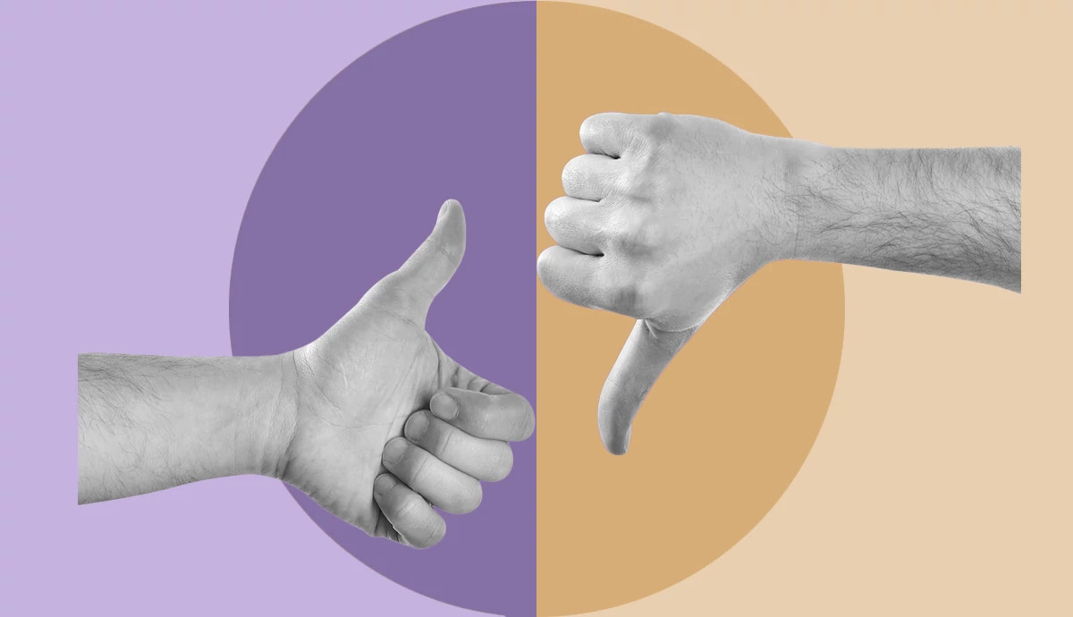 A close-up view of one hand giving a thumbs up and another giving a thumbs down