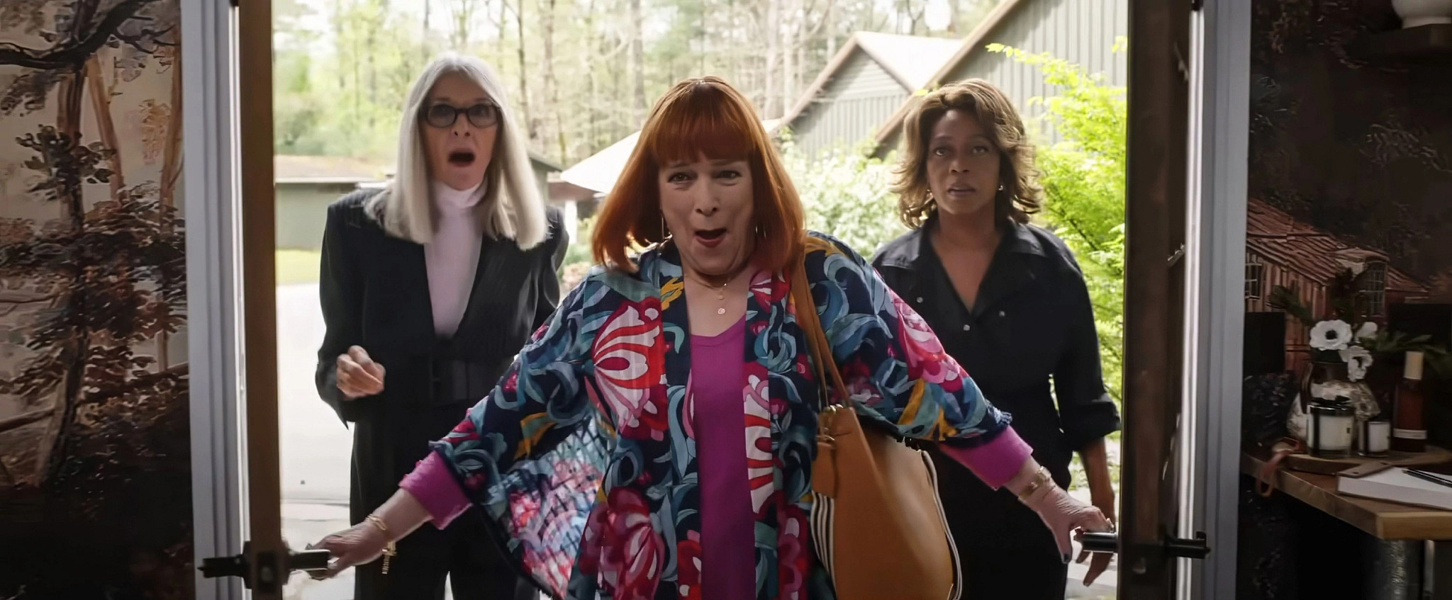 (Left to right) Diane Keaton, Kathy Bates and Alfre Woodard enter a home together through open front doors during daylight