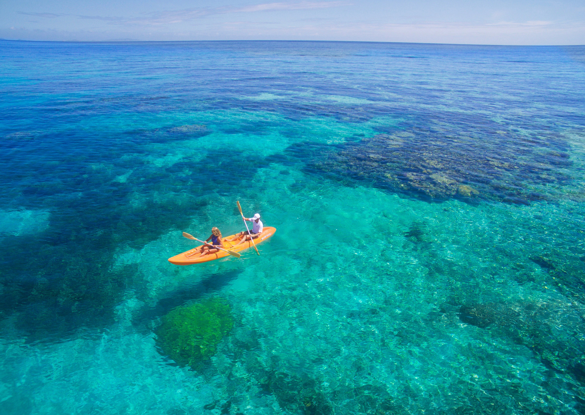 kayakers in fiji in the turquoise waters 