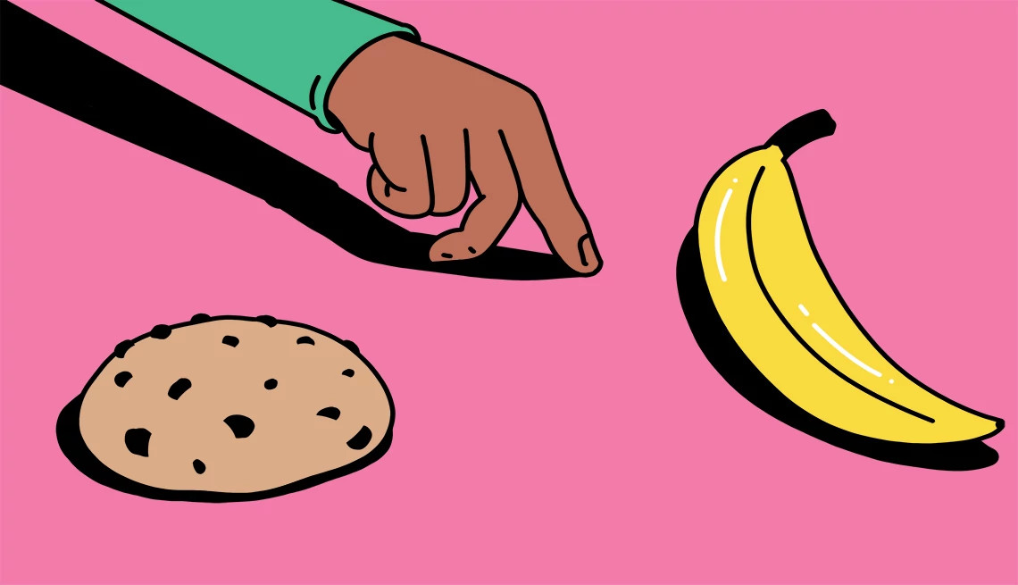 a man reaching for a banana over a chocolate chip cookie