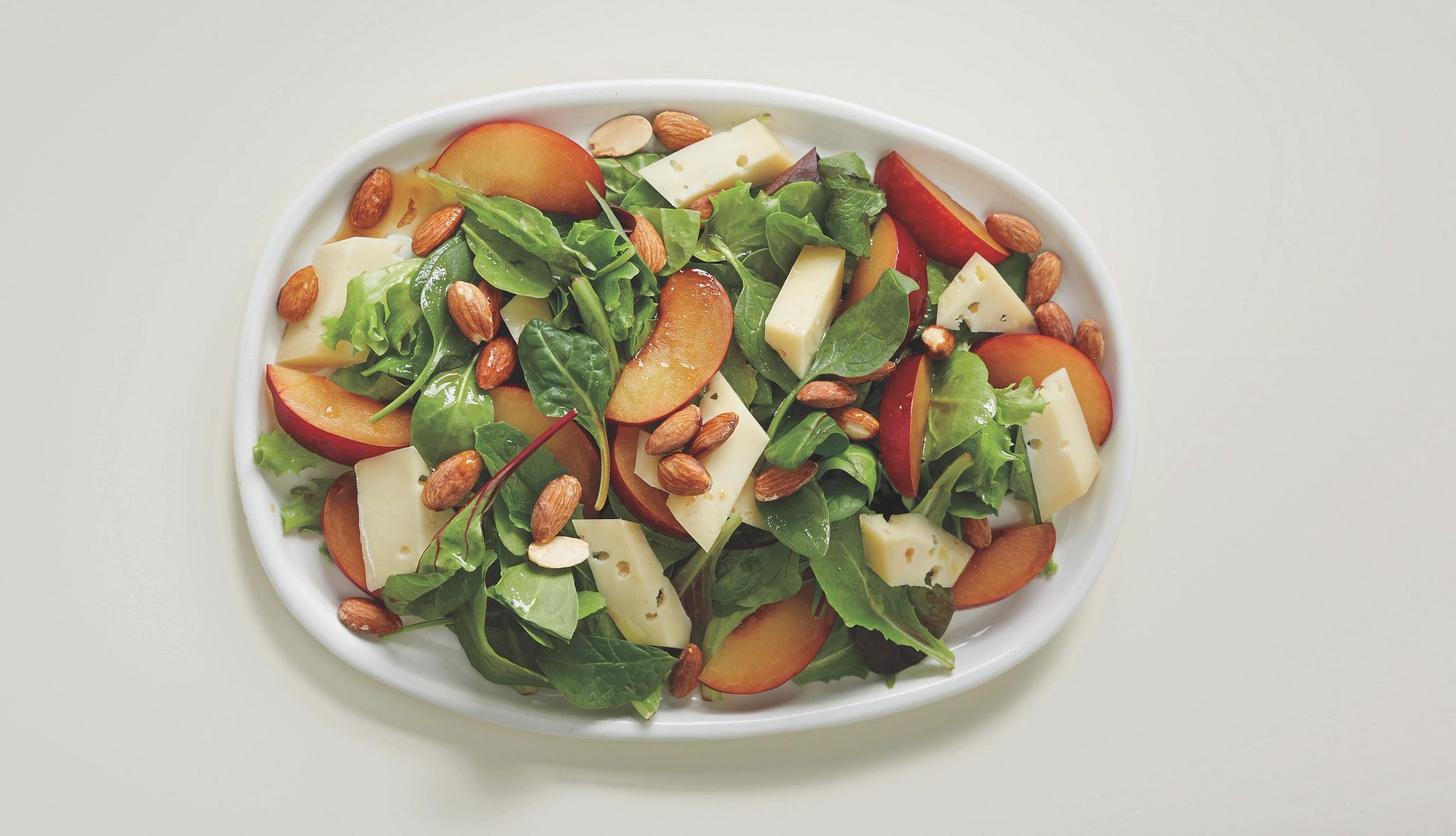 Mark Bittman's Green Salad with Plums A photo shows Mark Bittman’s light green salad with plums, fontina and almonds