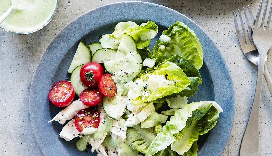 A close-up view of green goddess salad with chicken on a plate