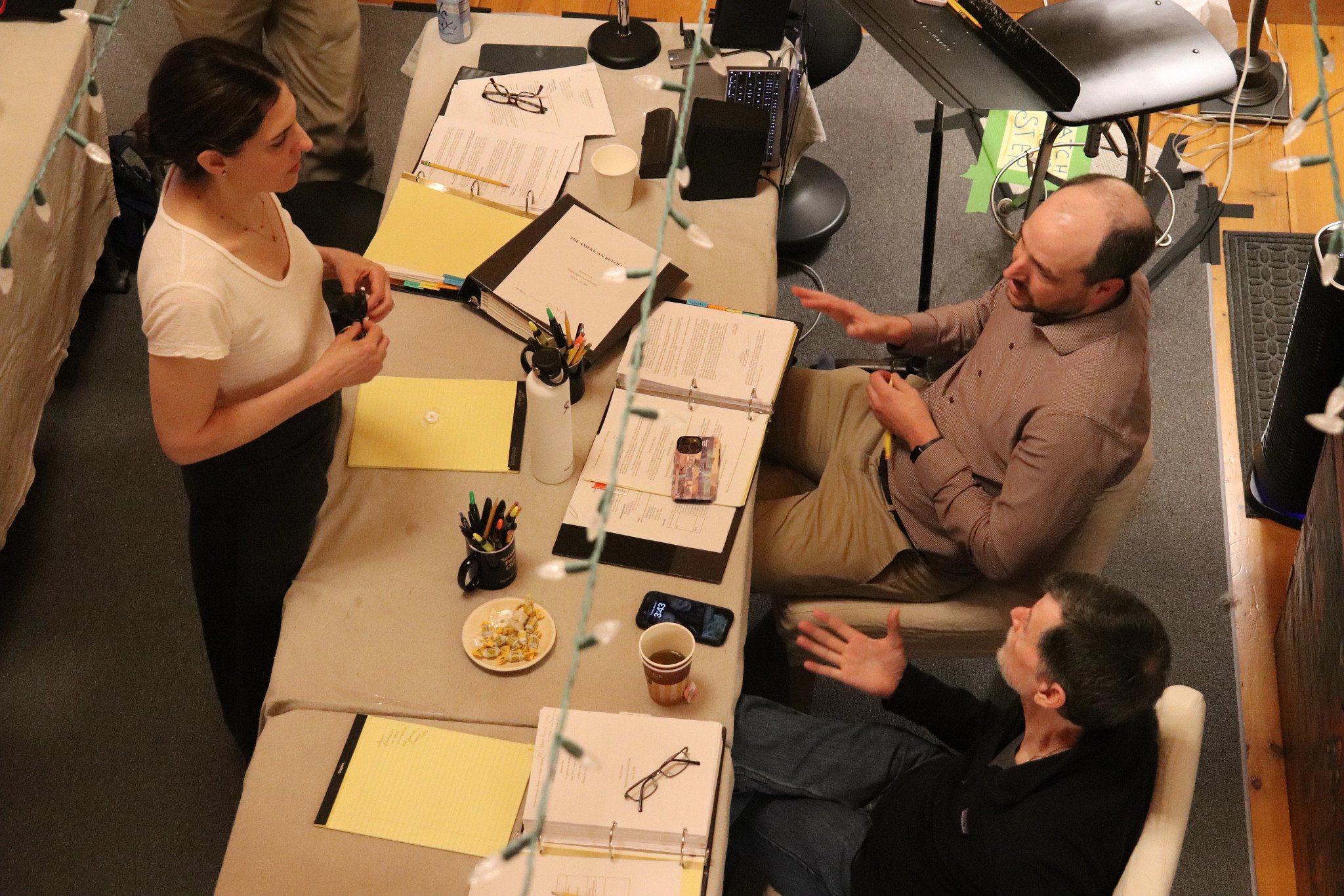 ken burns sarah botstein and david schmidt holding a meeting at a table